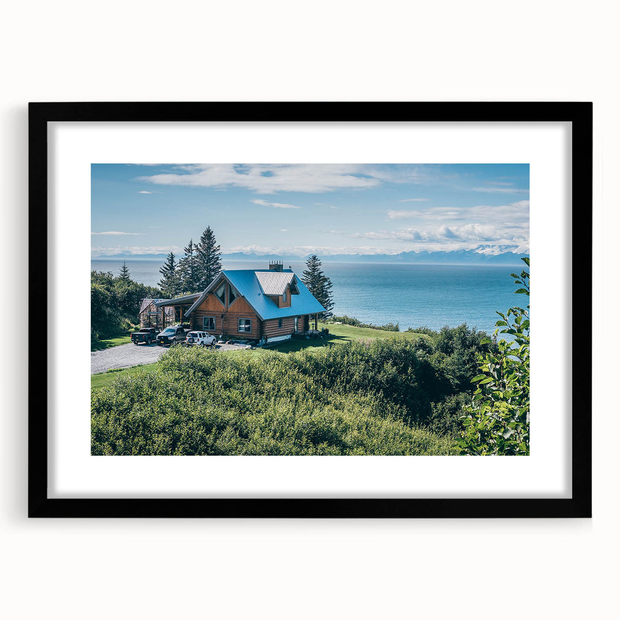 Black-framed wall art showcasing a serene countryside landscape, featuring lush green fields and a soft blue sky, ideal for home decor and interior design.