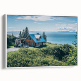 Framed canvas wall art depicting a serene countryside landscape with vibrant greenery and a blue sky. The piece is elegantly showcased with a white frame, enhancing its aesthetic appeal. Perfect for home decor, it adds a tranquil touch to any room.