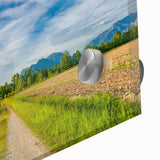 Close-up of a vibrant acrylic glass wall art piece showcasing a serene countryside landscape, featuring lush green fields and a clear blue sky, perfect for home decor.