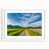 Framed wall art featuring a scenic countryside landscape design, showcasing vibrant greens and soft blues, elegantly matted in white for a refined look. Ideal for home decor.