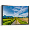 Framed canvas wall art showcasing a serene countryside landscape design, featuring vibrant green fields and a clear blue sky, presented in a sleek black frame.