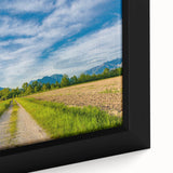 Framed canvas wall art featuring a serene countryside landscape, showcasing lush green fields and a vibrant sunset, ideal for home decor.