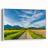 Framed canvas wall art showcasing a serene countryside landscape design, featuring lush green fields and a bright blue sky, ideal for home decor enhancement.
