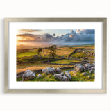 Framed wall art showcasing a serene countryside landscape, featuring vibrant green fields, a clear blue sky, and delicate white clouds, presented in a sleek silver frame with a mat for an elegant display.