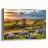 Framed wall art of a serene countryside landscape featuring rolling hills and a vibrant sunset, elegantly presented with a sleek silver frame, perfect for home decor.