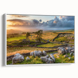 Framed canvas wall art depicting a serene countryside landscape with rolling hills and a vibrant sunset, featuring a white frame for modern aesthetics.
