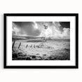 Framed landscape wall art featuring a serene countryside scene with vibrant green fields and a bright blue sky, encased in a stylish black frame with a mat.