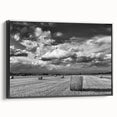 Framed canvas wall art showcasing a serene countryside landscape with vibrant greenery and soft clouds. The black frame enhances the artwork's elegance, perfect for home decor.