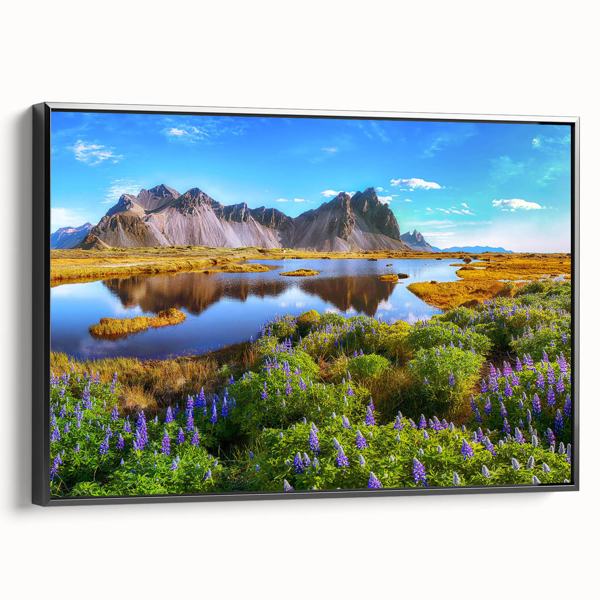 Framed canvas wall art showcasing a serene countryside landscape with vibrant greens and blues, elegantly displayed in a sleek black frame, perfect for home décor.
