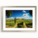 Framed wall art showcasing a serene countryside landscape with vibrant green fields and a bright blue sky, accented by a sleek silver frame and matting.