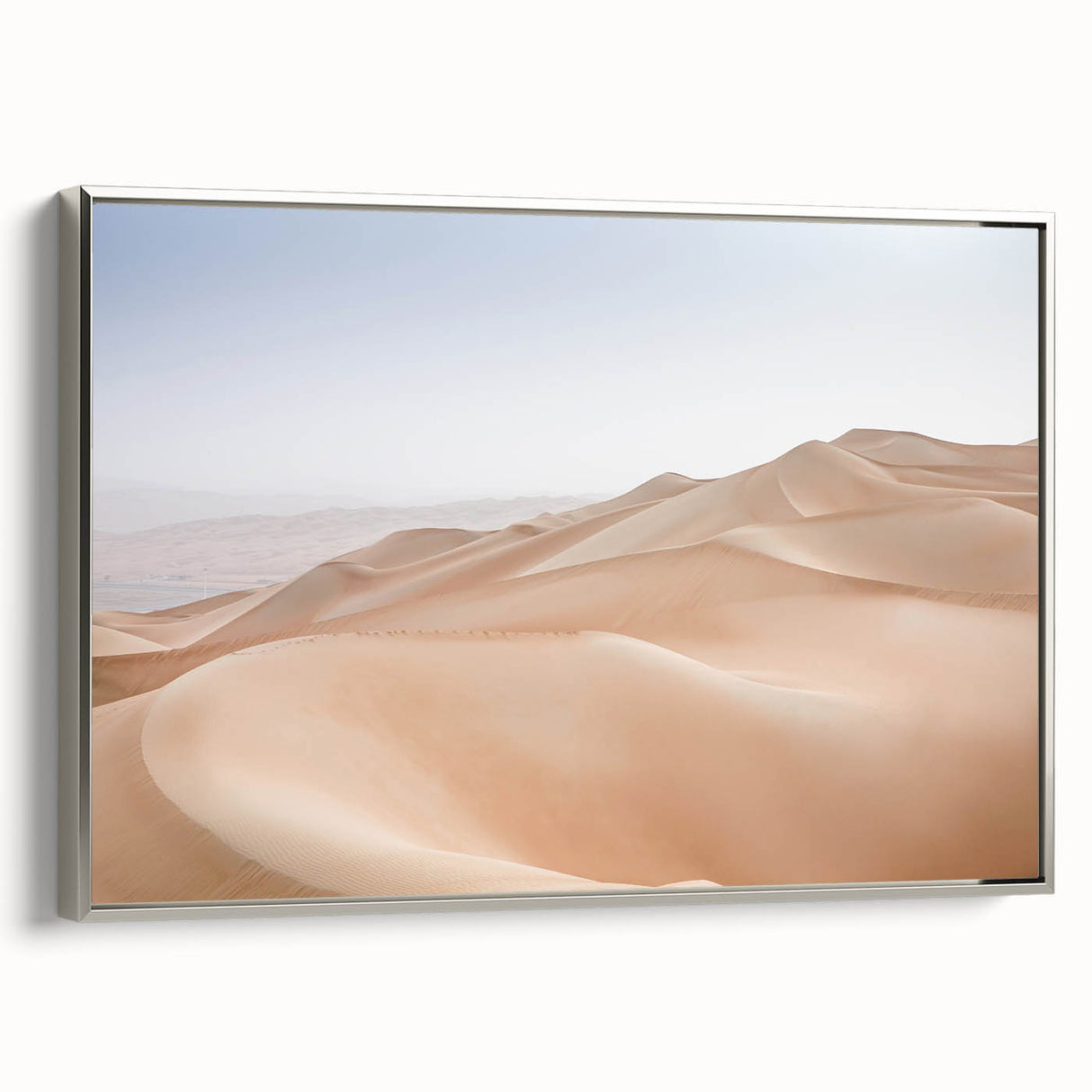 Framed wall art of a desert landscape design featuring warm tones of orange and gold, elegantly mounted in a sleek silver frame to enhance any decor.