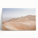 Stretched canvas artwork showcasing a vibrant desert landscape with warm colors, ideal for home decor, leaning against a wall for an artistic display.