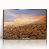 Framed acrylic wall art featuring a stunning desert landscape in silver tones, showcasing rugged mountains and a clear blue sky, ideal for modern home decor.