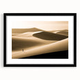 Framed wall art featuring a serene desert landscape with rolling dunes, presented in a sleek black frame and white mat, ideal for home decor enhancement.