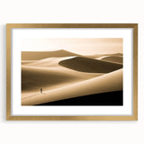 Framed wall art showcasing a serene desert dune landscape in soft gold tones, ideal for home decor, featuring a mat for added elegance and dimension.