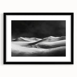 Framed wall art featuring a serene desert landscape with dunes, presented in a sleek black frame with a mat, perfect for modern home decor.