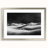 Framed wall art featuring a serene desert landscape with rolling dunes, presented in a sleek silver frame with a mat, ideal for home decor enhancement.