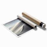 Desert landscape wall art print showcasing golden sand dunes under a vibrant blue sky, rolled and ready for display in home decor settings. Perfect for adding a serene touch to any room.