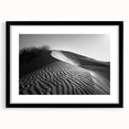 Framed wall art featuring a serene desert landscape with golden sand dunes, set in a sleek black frame with a white mat, perfect for modern home decor.
