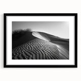 Framed wall art featuring a serene desert landscape with golden sand dunes, set in a sleek black frame with a white mat, perfect for modern home decor.