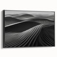 Framed canvas wall art showcasing an abstract design of sandy dunes in warm tones, featuring a sleek black frame from a side view, perfect for modern decor.