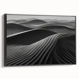 Framed canvas wall art showcasing an abstract design of sandy dunes in warm tones, featuring a sleek black frame from a side view, perfect for modern decor.