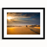 Framed wall art showcasing a serene desert landscape with rolling dunes, elegantly matted and presented in a sleek black frame, perfect for modern home decor.
