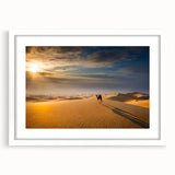 Framed wall art featuring a serene desert landscape with rolling sand dunes, presented in a modern white frame with a mat, enhancing any contemporary decor.