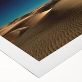 Rolled canvas showcasing a serene desert landscape with golden dunes and a vibrant sunset, ideal for modern home decor, packaged securely for delivery.