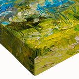 Close-up of a vibrant stretched canvas artwork depicting a serene landscape of rolling fields, featuring rich greens and golden hues, ideal for home decoration.