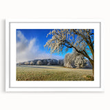 Framed wall art showcasing a serene landscape of golden fields under a bright blue sky, featuring a white mat and sleek frame, perfect for modern home decor.