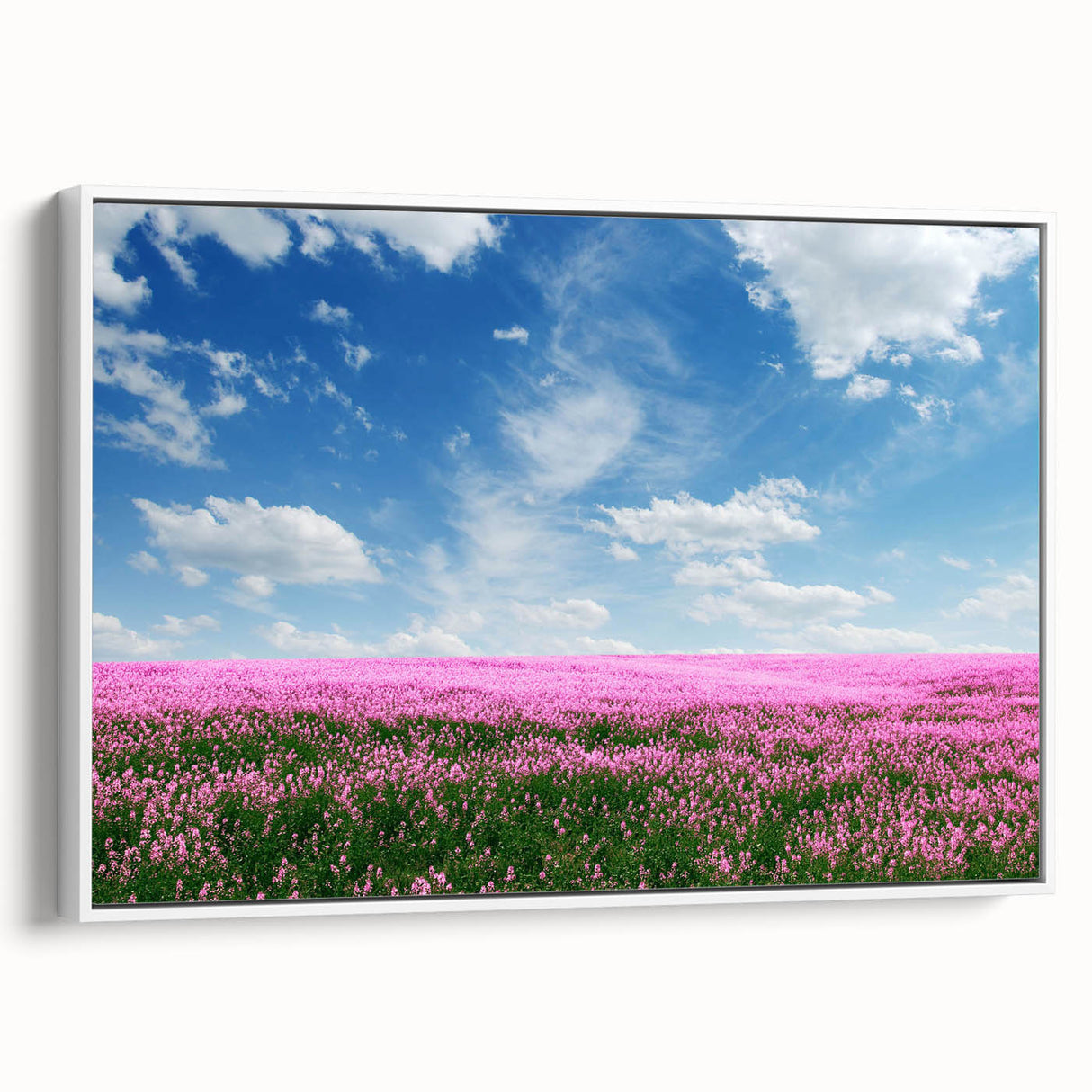Framed canvas wall art showcasing a serene landscape with vibrant green fields and a clear blue sky, elegantly displayed in a white frame, perfect for home decor.
