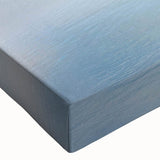 Close-up of a vibrant stretched canvas featuring a coastal harbor scene with rich blues and greens, perfect for home decor in coastal-themed interiors.