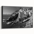 Framed canvas wall art showcasing a serene harbor landscape design, featuring vibrant blues and greens. The artwork is displayed in a sleek black frame, enhancing its visual appeal. Perfect for adding a touch of tranquility to modern home decor.