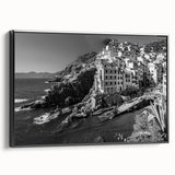 Framed canvas wall art showcasing a serene harbor landscape design, featuring vibrant blues and greens. The artwork is displayed in a sleek black frame, enhancing its visual appeal. Perfect for adding a touch of tranquility to modern home decor.