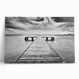 Stretched canvas wall art featuring a serene harbor landscape design in calming blue and green tones, elegantly leaning against a neutral wall, perfect for home decor.