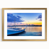 Elegant wall art featuring a gold-framed landscape design of a serene harbor scene, complete with a mat, perfect for enhancing home decor in various settings.