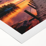 Rolled canvas artwork depicting a serene harbor landscape, showcasing vibrant blues and greens with textured details, elegantly packaged in a protective cardboard tube.