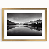 Framed wall art showcasing a serene lakeside landscape, featuring vibrant blues and greens, enclosed in a stylish gold frame with a mat for an elegant finish.