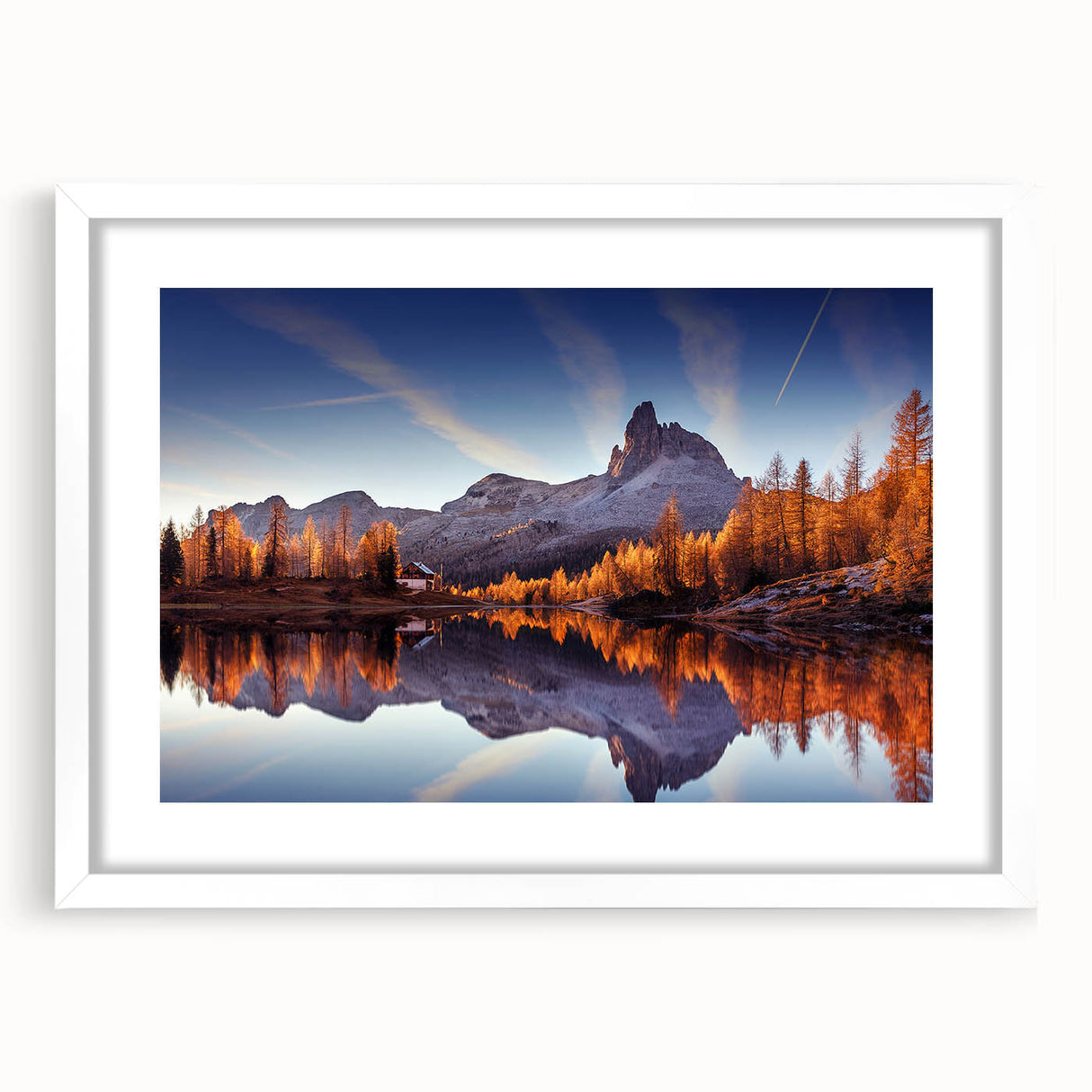 Framed wall art featuring a serene landscape of a tranquil lake surrounded by lush greenery, presented in a white mat and frame, ideal for home decor.