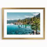 Framed wall art featuring a serene lake landscape with mountains in the background, elegantly presented with a gold mat, enhancing any home decor.