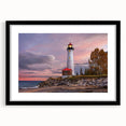 Black-framed wall art featuring a serene lighthouse design against a vibrant sunset backdrop, perfect for coastal-themed home decor. The mat adds an elegant touch, enhancing the overall aesthetic appeal.