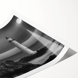 Vibrant rolled print showcasing a coastal landscape with a lighthouse set against a dramatic sunset, ideal for enhancing home decor or office spaces.