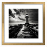 Framed wall art featuring a coastal landscape with a lighthouse, presented in a gold frame with a white mat, ideal for home decor and beach-themed interiors.