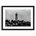 Framed landscape wall art featuring a serene lighthouse design with vibrant colors, black matting, and a sleek black frame, perfect for coastal-themed decor.