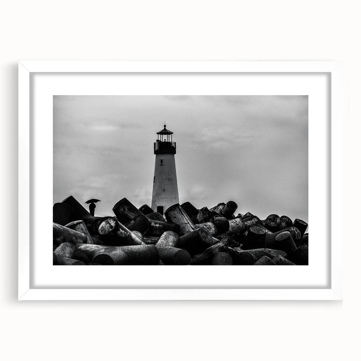 Framed wall art featuring a coastal lighthouse design, mounted with a white mat, showcasing tranquil ocean waves and a bright blue sky, perfect for enhancing home decor.