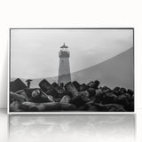Framed wall art featuring a serene lighthouse design against a vivid sunset backdrop, showcasing bright colors and modern acrylic framing for stylish decor.