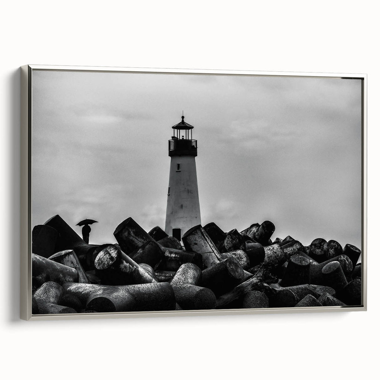 Framed canvas wall art showcasing a serene lighthouse landscape, featuring a silver frame and vibrant colors, perfect for coastal-themed decor.