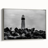 Framed canvas wall art showcasing a serene lighthouse landscape, featuring a silver frame and vibrant colors, perfect for coastal-themed decor.