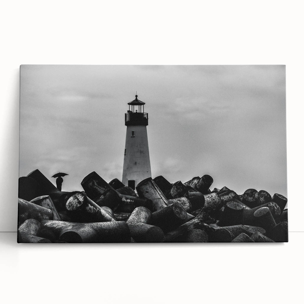 Stretched canvas art showcasing a scenic lighthouse design with vibrant colors, perfect for coastal-themed decor, leaning against a white wall.